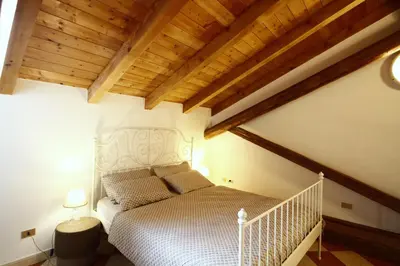 a bedroom with a bed in a room with wooden ceilings at Casa Nido sul Cermis in Varena