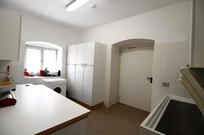 a kitchen with white walls and a white refrigerator at Casa Nido sul Cermis in Varena