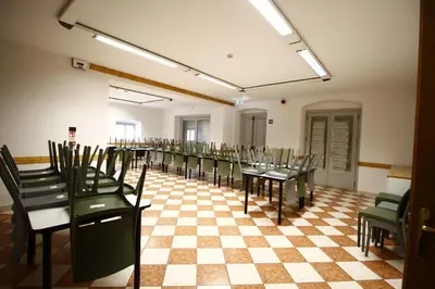 a room with tables and chairs on a checkered floor at Casa Nido sul Cermis in Varena