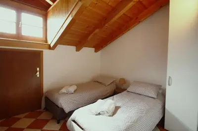 two beds in a room with a skylight at Casa Nido sul Cermis in Varena