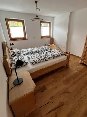 a bedroom with a bed with a lamp on a wooden floor at Villa Moos Appartement in Colle Isarco