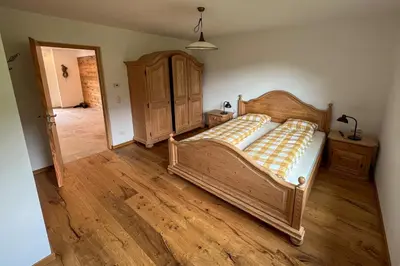 a bedroom with a bed and a wooden floor at Villa Moos Appartement in Colle Isarco