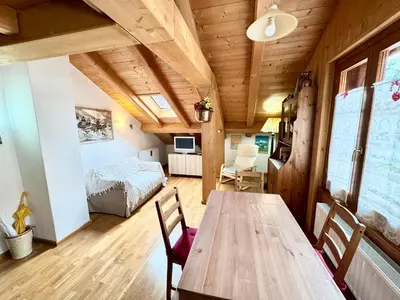 a room with a wooden table and a bedroom at Ciasa De Cin - 10 minutes from Cortina in San Vito di Cadore