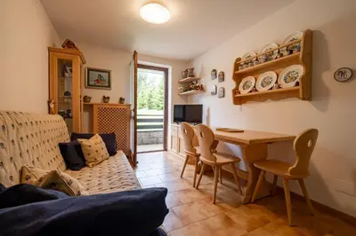 a living room with a table and chairs at Casa Lugli by go new location in Cavalese