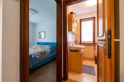 a bathroom with a sink and a bed in a room at Casa Lugli by go new location in Cavalese