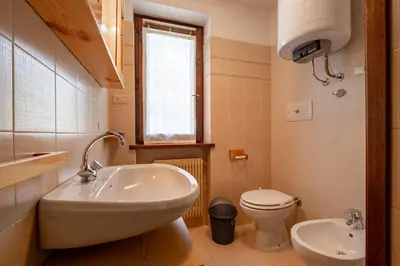 a small bathroom with a sink and a toilet at Casa Lugli by go new location in Cavalese