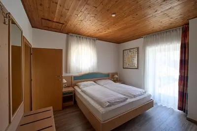 a bedroom with a bed and a wooden ceiling at Hotel Zur Post in Egna