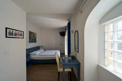 a bedroom with a blue desk and a bed at Hotel Zur Post in Egna