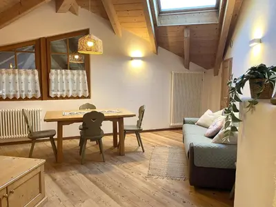 a living room with a table and a couch at Mansarda Ai Tigli in Castello di Fiemme