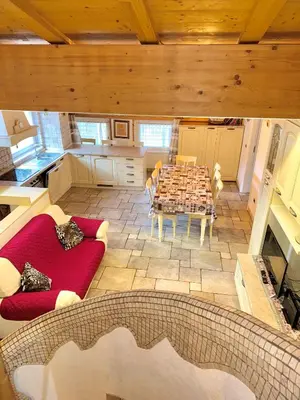 a living room with a table and a red couch at Sweet Home in Moena