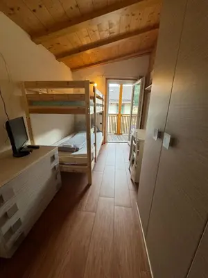 a room with a bunk bed and a desk with a computer at Sweet Home in Moena