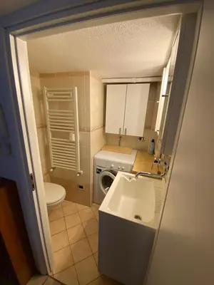 a small bathroom with a sink and a washing machine at Sweet Home in Moena