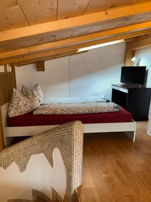 a bedroom with a bed and a desk with a laptop at Sweet Home in Moena