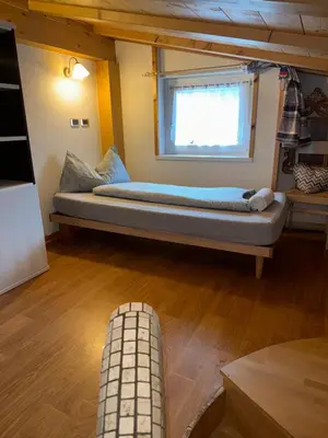 a bed sitting in a room with a window at Sweet Home in Moena