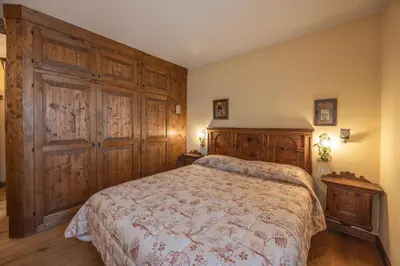 a bedroom with a bed with wooden panels and a wooden cabinet at Casa Sette, in centro a Cortina d Ampezzo in Cortina dʼAmpezzo