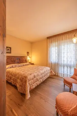 a bedroom with a large bed and a window at Casa Sette, in centro a Cortina d Ampezzo in Cortina dʼAmpezzo
