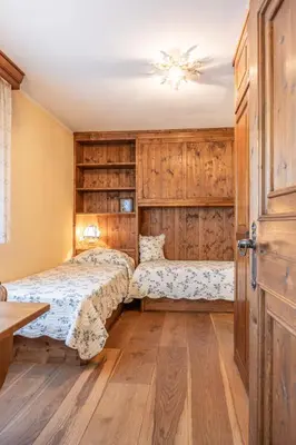 two beds in a room with wooden cabinets at Casa Sette, in centro a Cortina d Ampezzo in Cortina dʼAmpezzo