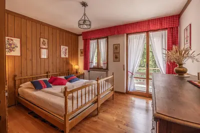 a bedroom with a bed in a room with wooden walls at Casa Ca del Molin, ampia e panoramica in Cortina dʼAmpezzo