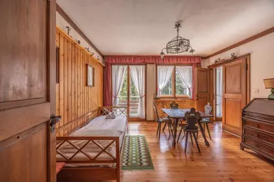 a room with a bed and a table in it at Casa Ca del Molin, ampia e panoramica in Cortina dʼAmpezzo