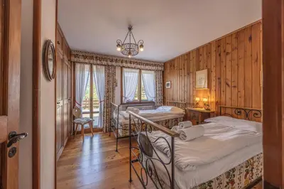 a bedroom with two beds and a window at Casa Ca del Molin, ampia e panoramica in Cortina dʼAmpezzo