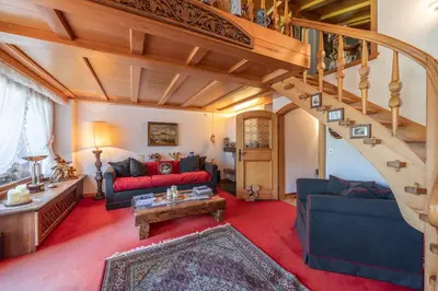 a living room with a staircase and blue couches at Casa Benedeta, confortevole e panoramica in Cortina dʼAmpezzo