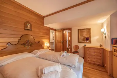 two beds in a room with wooden walls at Casa Benedeta, confortevole e panoramica in Cortina dʼAmpezzo