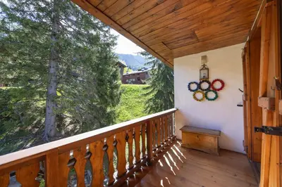 a balcony of a cabin with a view of trees at Casa Benedeta, confortevole e panoramica in Cortina dʼAmpezzo