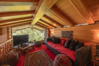 a living room with a couch and a tv at Casa Benedeta, confortevole e panoramica in Cortina dʼAmpezzo