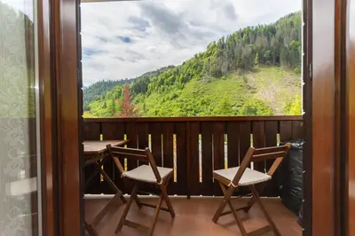 a balcony with two chairs and a view of a mountain at La Finestra sul Civetta in Alleghe