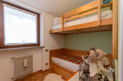 a bedroom with two bunk beds and a window at La Finestra sul Civetta in Alleghe
