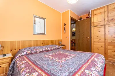 a bedroom with a king sized bed and a closet at La Finestra sul Civetta in Alleghe