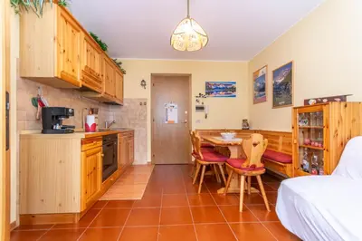 a kitchen with a table and chairs in a room at La Finestra sul Civetta in Alleghe