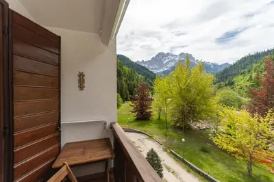 a balcony with a wooden door and a view of the mountains at La Finestra sul Civetta in Alleghe
