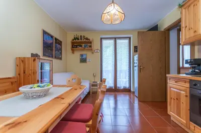 a kitchen with a table and a dining room at La Finestra sul Civetta in Alleghe