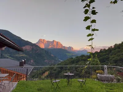 a balcony with tables and chairs and a view of mountains at Marxhof in Barbiano