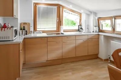 a kitchen with wooden cabinets and a window at Öboluckna Appartment in Molini di Tures