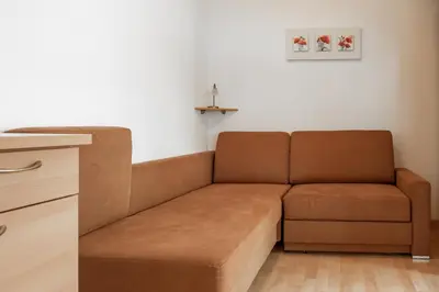 a brown couch sitting in a living room at Öboluckna Appartment in Molini di Tures