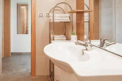 a bathroom with a white sink and a mirror at Öboluckna Appartment in Molini di Tures