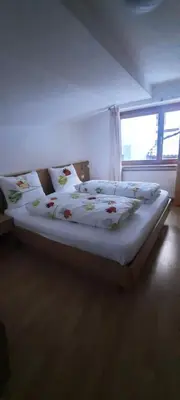 a large bed in a room with a window at Öboluckna Appartment in Molini di Tures