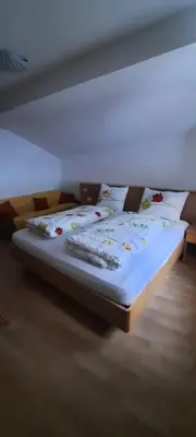a bed with white sheets and pillows in a room at Öboluckna Appartment in Molini di Tures