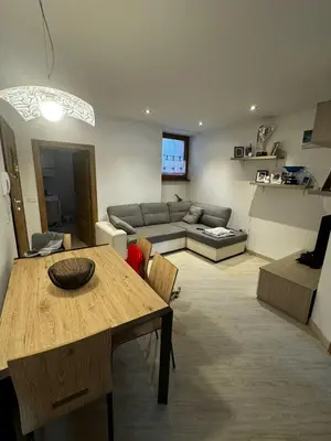 a living room with a table and a couch at Casa Angelini in Castello di Fiemme