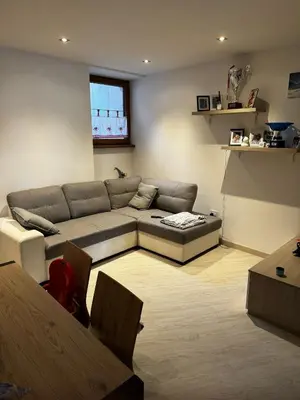 a living room with a couch and a table at Casa Angelini in Castello di Fiemme