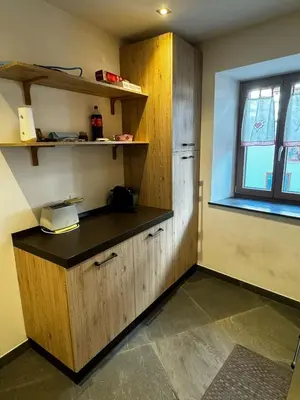 a kitchen with wooden cabinets and a window at Casa Angelini in Castello di Fiemme