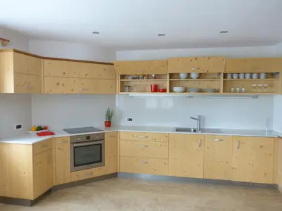 a kitchen with wooden cabinets and a sink at Ciasa Roenn in Colfosco