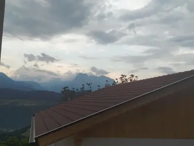 a roof of a house with mountains in the background at Mitterhofer Appartements in Villandro
