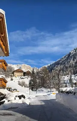 a brown door with a wreath on top of it at Appartamento Lagazuoi nel cuore delle Dolomiti in Livinallongo del Col di Lana