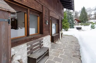 a bench on the side of a building at Comfort loft, appartamento centrale con giardino in Cortina dʼAmpezzo