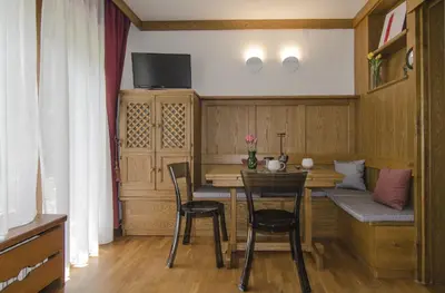 a small dining room with a table and chairs at Comfort loft, appartamento centrale con giardino in Cortina dʼAmpezzo