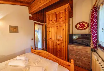 a bedroom with a bed and a tv in a room at Casa Mary in San Vito di Cadore