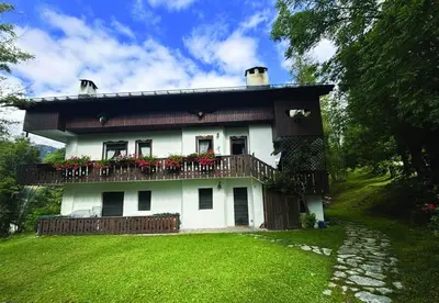 a house with a balcony with flowers on it at Casa Mary in San Vito di Cadore